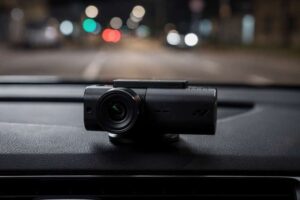 Una dashcam montata sul parabrezza di un'auto che registra la strada di notte con visione infrarossi in alta definizione.
