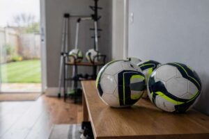 Giocatore che controlla il pallone durante una partita su un campo di erba naturale.