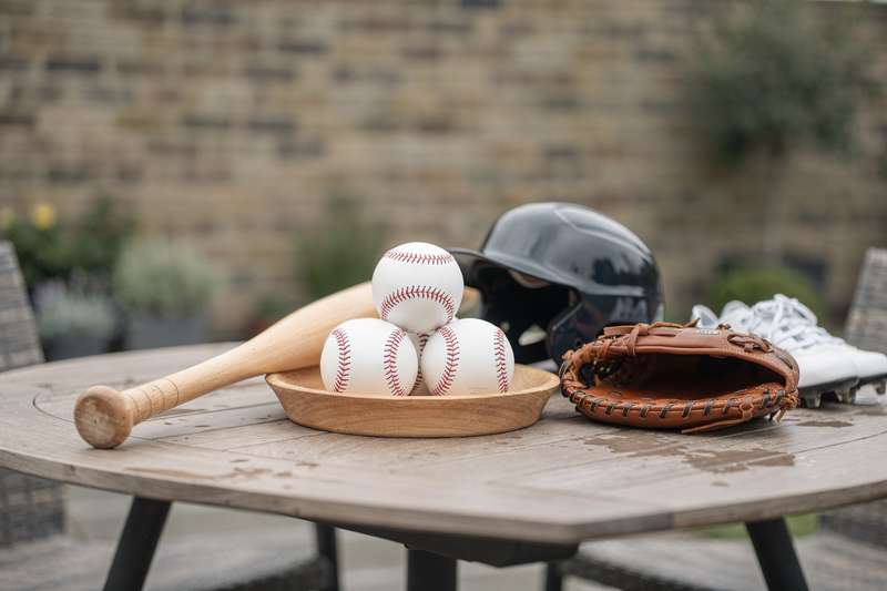 Giocatore che colpisce la palla con mazza da baseball durante un'allenamento in campo aperto.