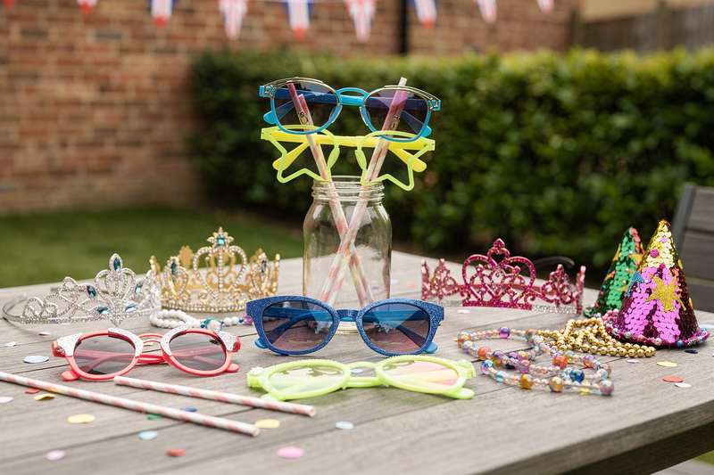 Una persona indossa occhiali da festa colorati e brilla durante una celebrazione in gruppo.