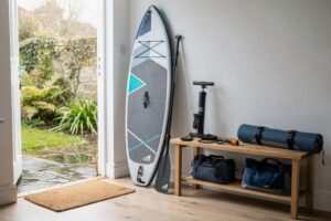 Una persona in equilibrio su una tavola da SUP in acque tranquille mentre tiene il remo con entrambe le mani.